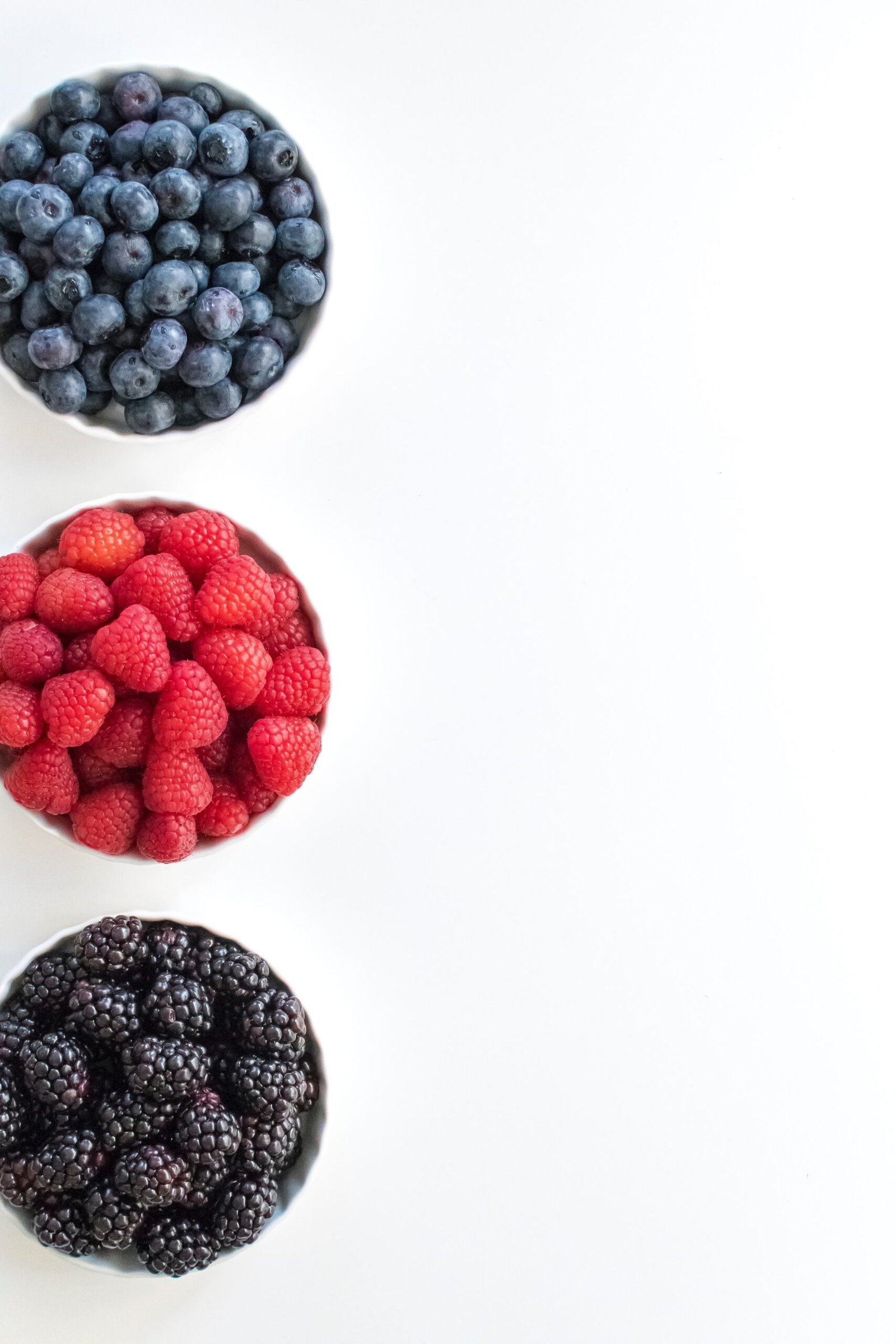 red and black berries on white surface